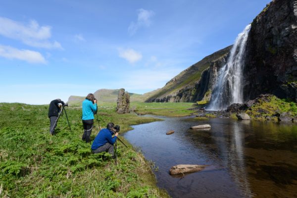 Photographes devant une cascade dans la baie D'Hornvik, Hornstrandir Islande