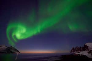Aurore boréale en volute, au coucher du soleil avec au milieu la comète de pannstarrs, Senja Norvège